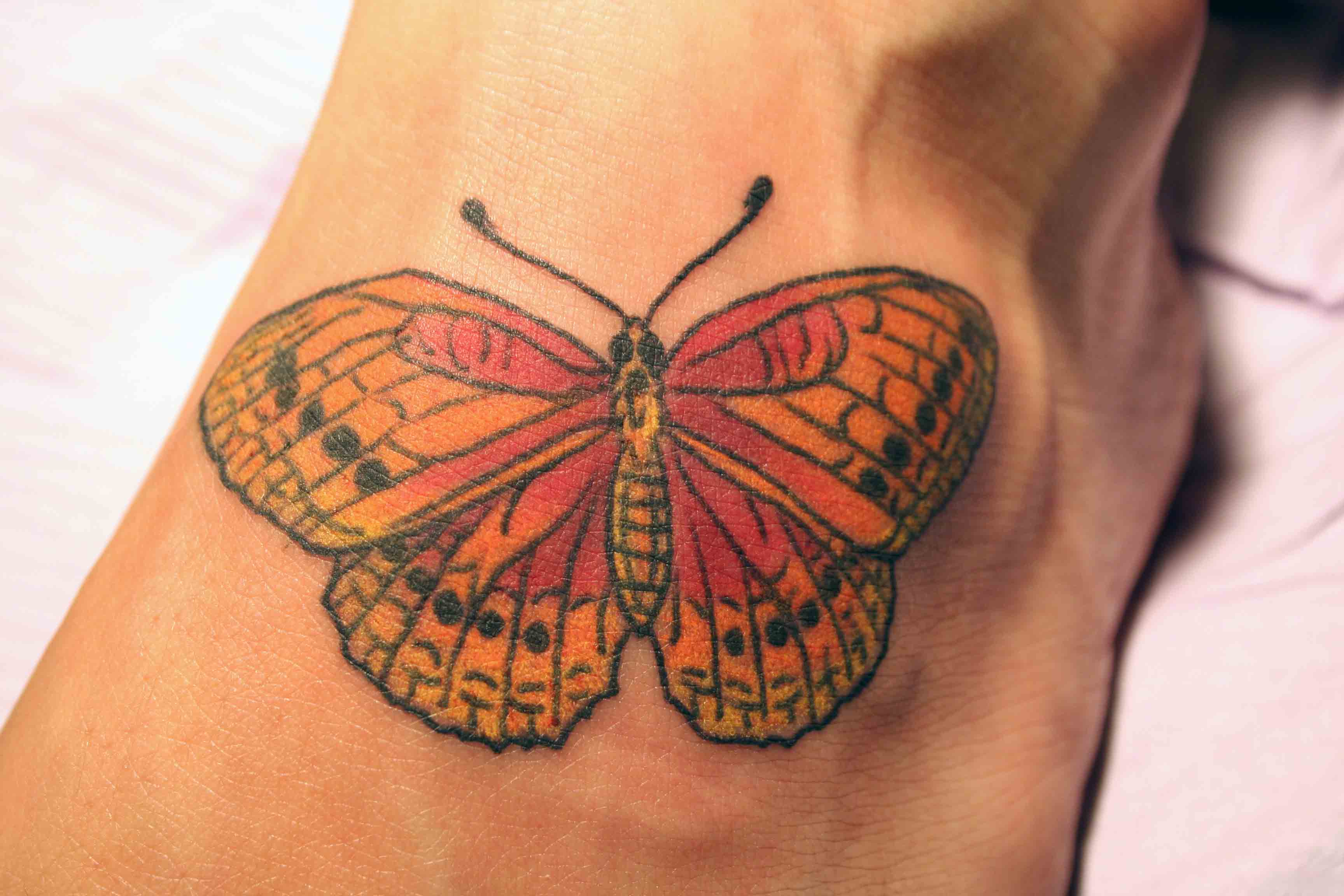 Butterfly foot tattoo by Tom